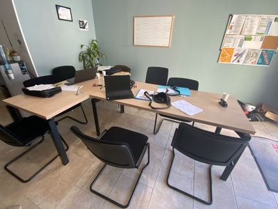 a table with chairs and a laptop on it in a room