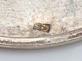 a silver plate that has a small piece of metal on it