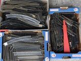 two boxes of train tracks that are sitting on the ground