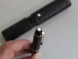 a person holding a pen in their hand next to a pen