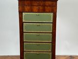 une commode ancienne en bois dont les tiroirs sont peints en vert