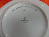 a white plate with writing on it on an orange table