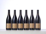 six bottles of red wine lined up in a row