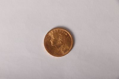 a small coin on a white surface with a white background