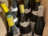six bottles of wine in a cardboard box on a table