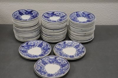 beaucoup d'assiettes bleues et blanches posées sur une table