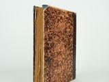 an old book that is sitting on a white surface