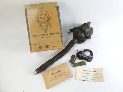 une boîte sur laquelle est représenté un masque à gaz, à côté d'une paire de ciseaux