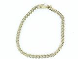 gros plan d'un bracelet en chaîne en or sur fond blanc