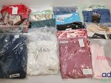 beaucoup de vêtements rangés dans des sacs posés sur la table