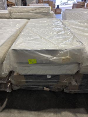 many mattresses stacked on top of each other in a warehouse