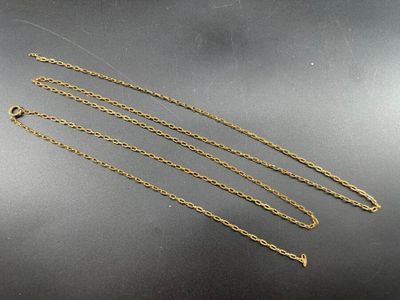 three gold chain necklaces on a black surface