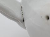 a close up of a white teapot on a white table