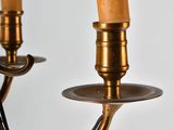 pair of brass candles on a white wall with a white background