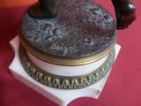 a figurine of a man on a pedestal on a red table