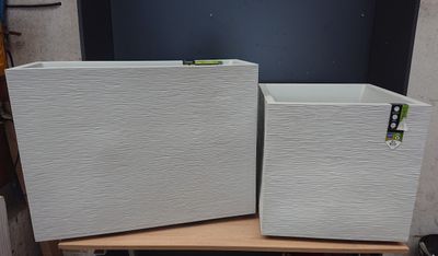 two white boxes sitting on top of a wooden table