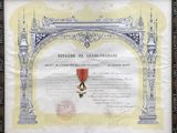 un vieux document orné d'un ruban rouge et d'une médaille