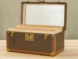 a small suitcase with a mirror in it on a table
