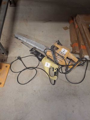 a picture of a chainsaw sitting on the floor next to a pile of wood