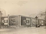 photographie en noir et blanc d'un immeuble sur la façade duquel figurent des publicités