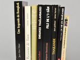 several books are stacked on top of each other on a white surface