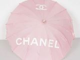 chanel logo umbrella in pink with white letters and a chanel logo on it