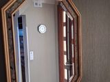 un miroir sur le mur au-dessus d'un lavabo dans une salle de bains