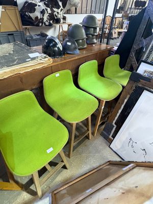 Plusieurs chaises vertes sont alignées en rang dans une pièce