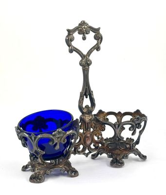 two blue glass bowls and a silver plate on a white background