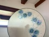 Dans une pièce, quelqu'un tient une assiette décorée de fleurs bleues.