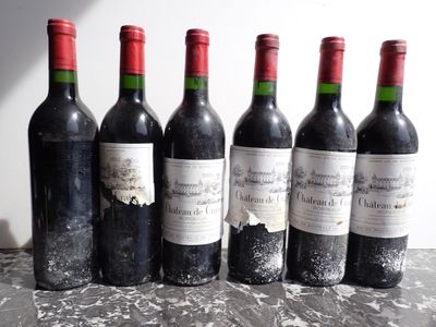 six bottles of red wine are lined up on a table