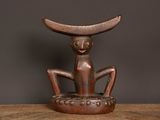 une vieille sculpture en bois représentant un chat assis sur une table en bois