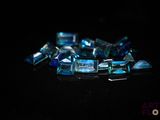 some very pretty blue glass pieces on a black surface
