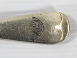 a silver spoon with a design on it sitting on a table