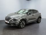 un SUV Nissan QX Sport gris garé dans un garage