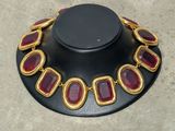an image of a necklace with red stones on it