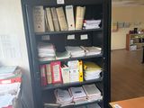 a room with a desk and a bookcase full of books