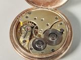 a close up of a pocket watch with gears inside of it
