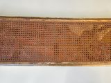 a wicker basket on the wall next to a white wall