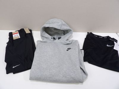 Un sweat à capuche, un pantalon de survêtement et d'autres pantalons de survêtement sont posés sur une table