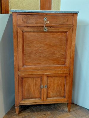 une armoire en bois avec un plateau en marbre, placée dans un coin
