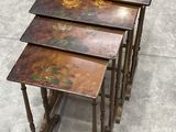 three wooden tables with painted flowers on them sitting on a cement floor