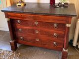 a dresser with a marble top and a vase on top