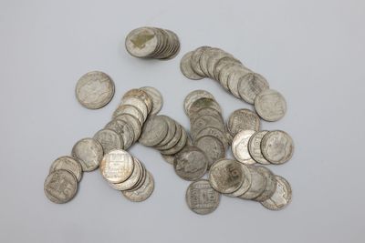 une pile de pièces d'argent sur une surface blanche