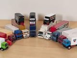Plusieurs camions miniatures sont alignés en cercle sur une table en bois