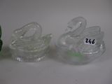 two glass swan figurines sitting next to each other
