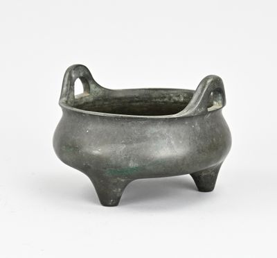 une vieille casserole en métal avec une poignée, posée sur une surface blanche