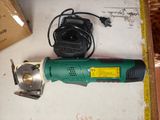 a green and black electric tool sitting on a table