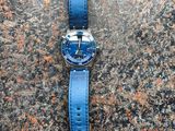 a close up of a watch sitting on a stone surface
