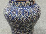 a blue and white vase sitting on the ground